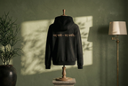 WOVYN Becoming Collection Hoodie - Obsidian Black in a styled interior, back view with Sanskrit embroidery “यत् भावो – तत् भवति”